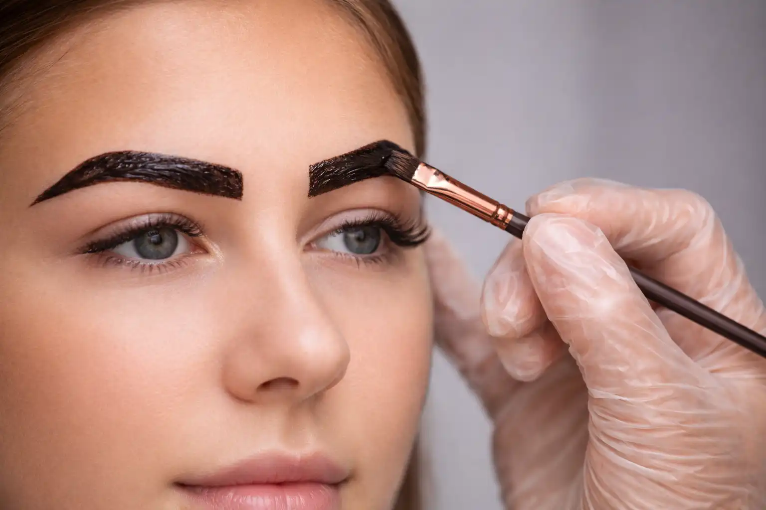 Close-up of brow shaping and tint application with laminated brows and lifted lashes