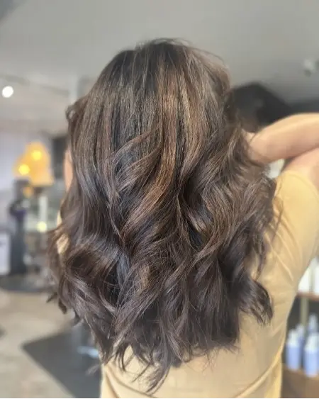 Dimensional brunette with soft highlights and waves at Studio 303 hair salon Englewood CO