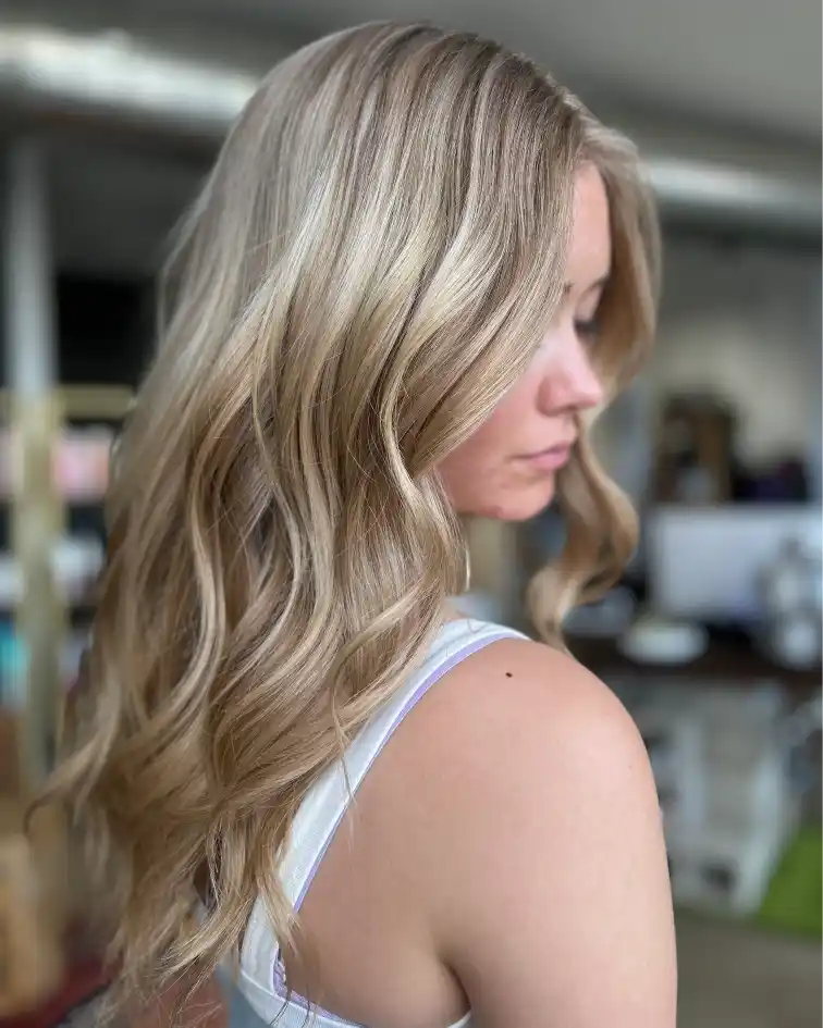 Dimensional cool blonde balayage with soft waves at Studio 303 hair salon in Englewood CO