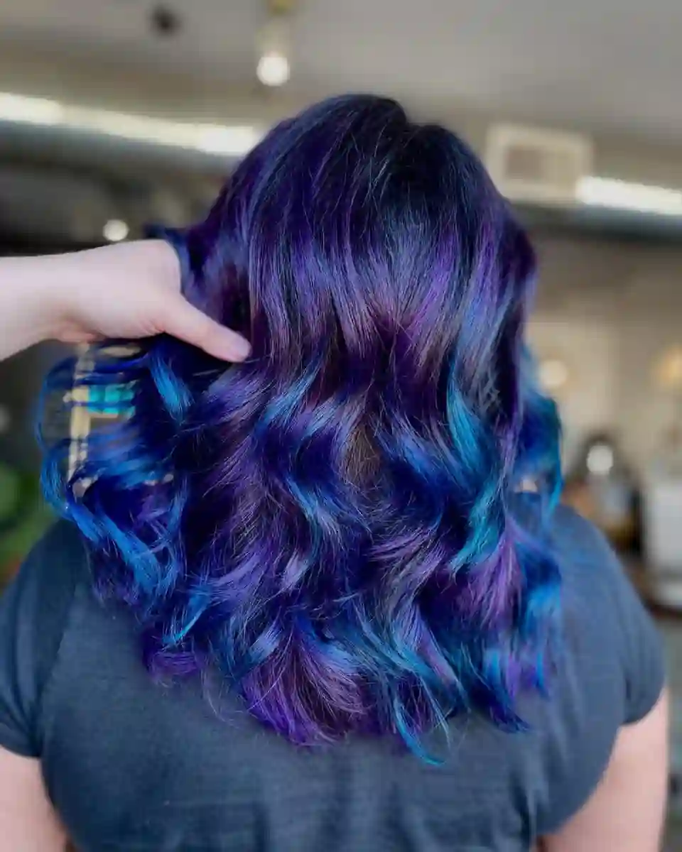 Blue and violet vivid hair color with dimensional waves at Studio 303 in Englewood, CO.