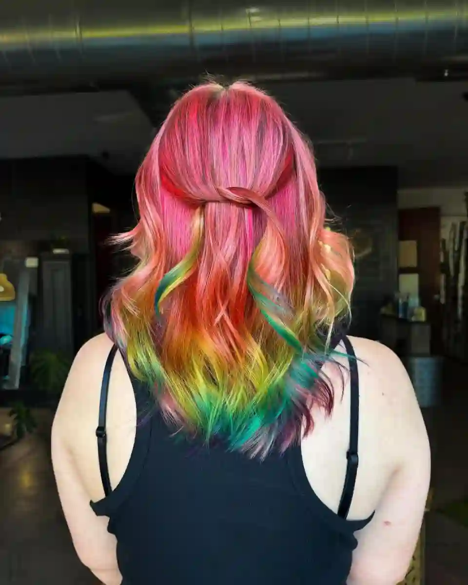 Pink vivid hair with hidden rainbow fashion color created at Studio 303 in Englewood, CO.