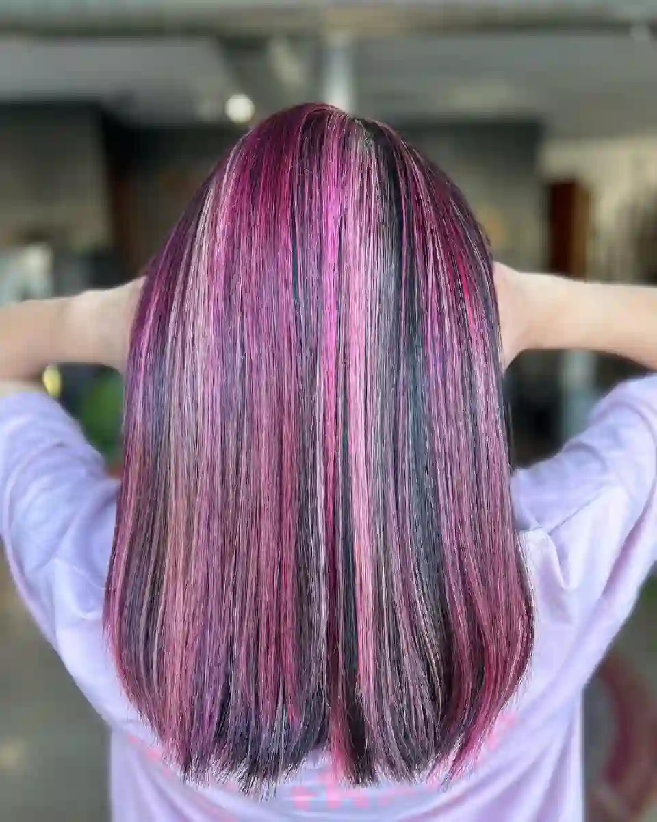 Plum and magenta vivid highlights on straight shoulder-length hair at Studio 303 in Englewood, CO.