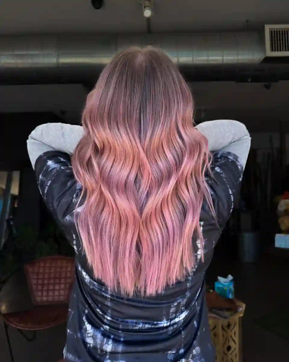Soft pink fashion hair color with dimensional waves at Studio 303 in Englewood, CO.